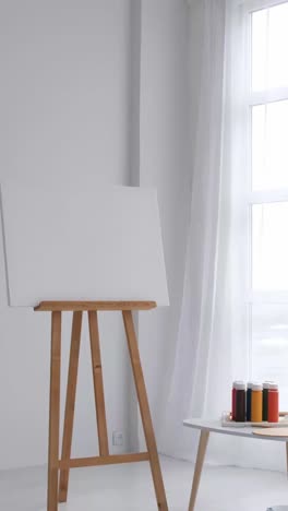 easel with canvas and art supplies