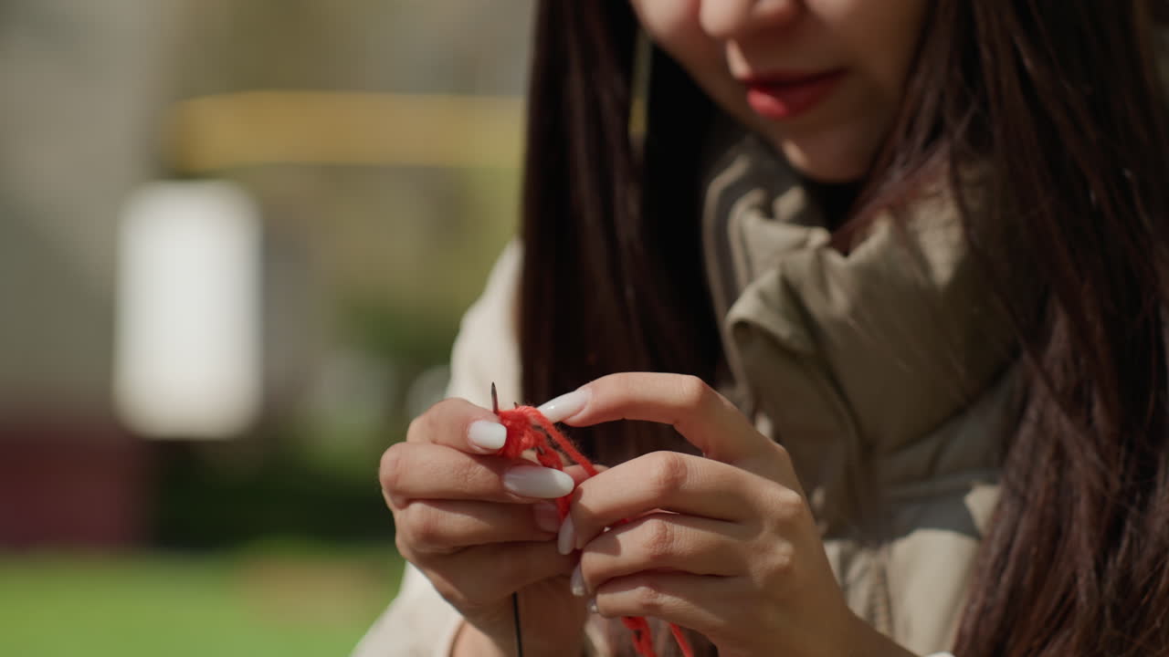 생생한 직물을 손으로 짜는 모습의 디테일 샷, 선명한 가을 스카프 디테일을 디자인하는 장인의 클로즈업, 복잡하고 다채로운 울 액세서리를 만드는 숙련된 장인의 집중된 이미지