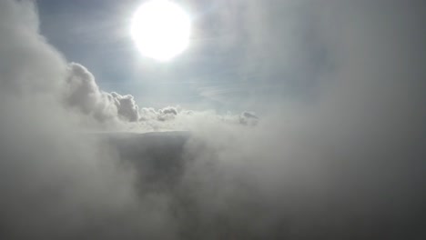 vuelo aéreo sobre las nubes con el sol brillando