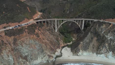 Luftbrummen-Stockvideo-Von-Bixby-Bridge-Highway-Mit-Wasser-Und-Ufer-Unten-In-Big-Sur-Monterrey-Kalifornien