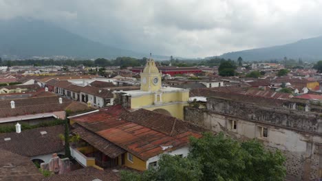 Pasando-La-Torre-Del-Reloj-Del-Arco-De-Santa-Catalina,-En-Antigua-Guatemala---Vista-Aérea