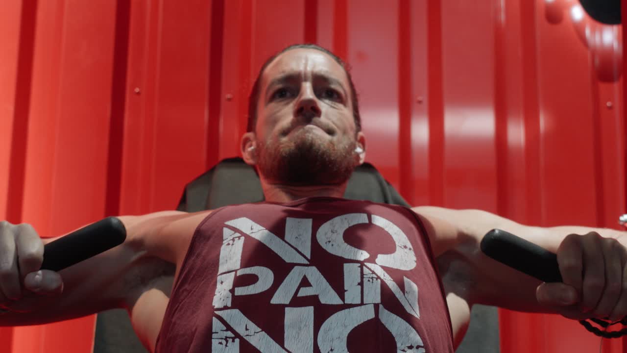 Culturista esforzándose por completar una serie completa de press de banca inclinado en máquina