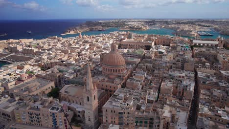 orbita ascendente alrededor de la basílica de nuestra señora cúpula mientras las nubes cubren los edificios de valletta, malta