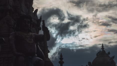 silhouette of sculptures against dramatic sky