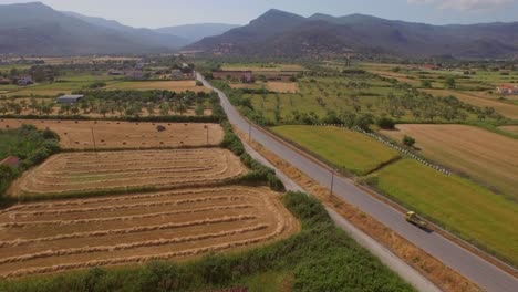 Aerial:-A-river-delta-with-a-road-bridge-passing-through-and-some-agricultural-buildings