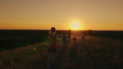 a group of children are running happily towards the sunset with the dog