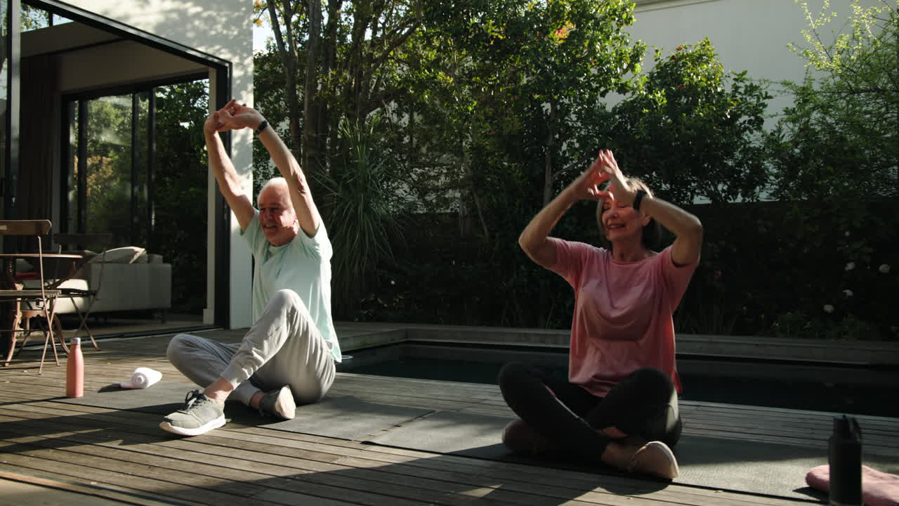 Senior couple enjoying outdoor yoga session together on sunny patio