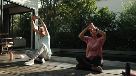 senior couple enjoying outdoor yoga session together on sunny patio