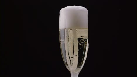 champagne bubbles rotating inside wine glass a closeup shot of a champagnefilled flute glass with bubbles rotating inside in slow motion against a dark background