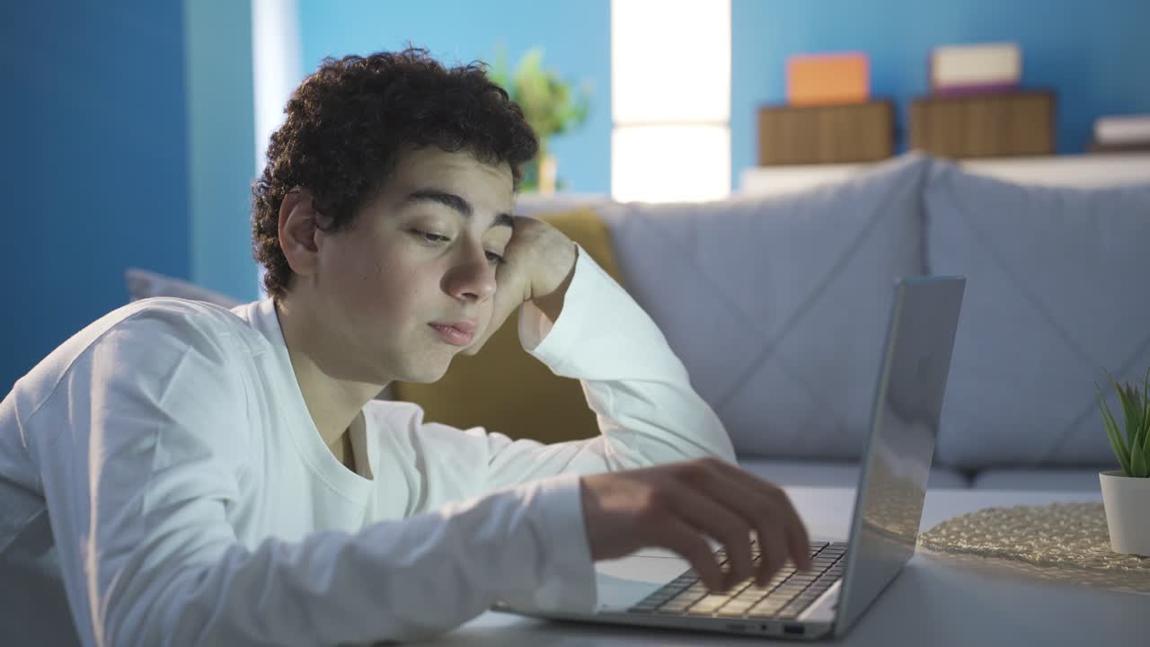 Ung mann bruker laptop i en kjedelig og deprimert tilstand