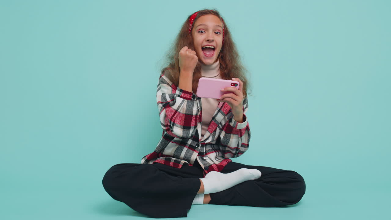 niña emocionada preocupada jugando a carreras o simulador de disparos aplicación de gadget videojuegos en el teléfono inteligente