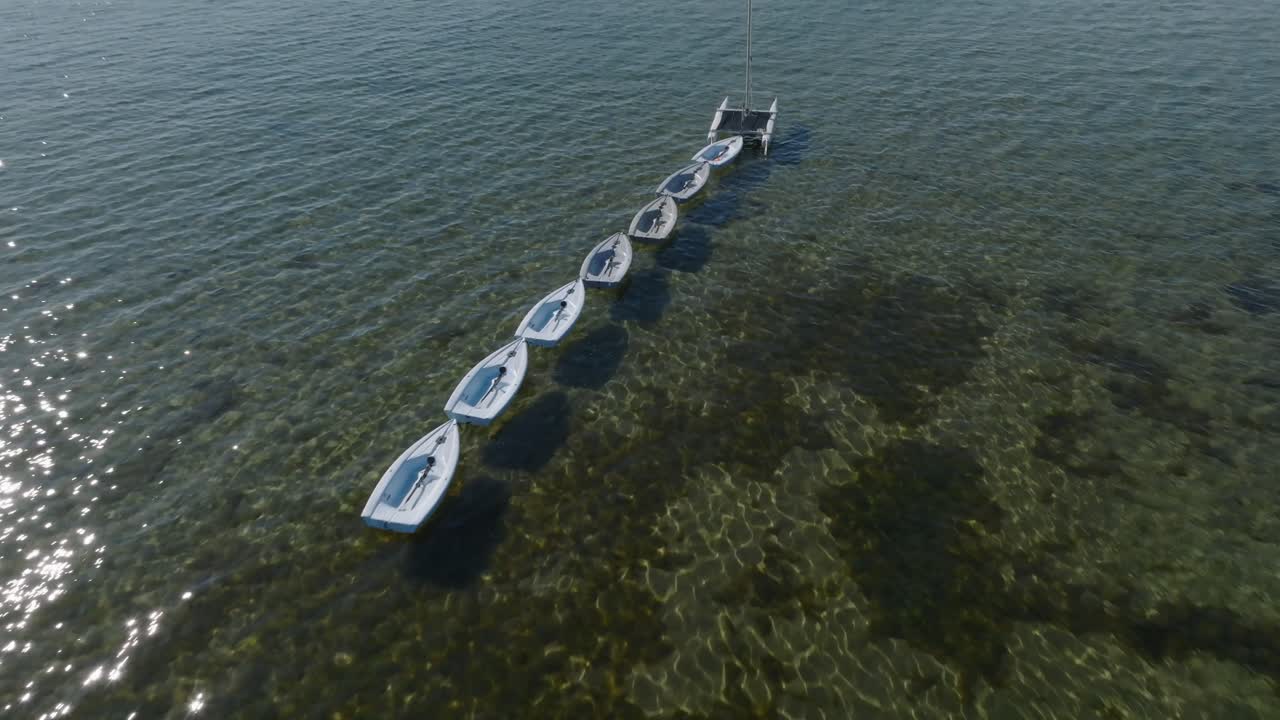 establecimiento de tiro con inclinación hacia abajo de una cadena de pequeñas embarcaciones en aguas cristalinas
