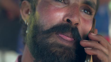 indian man close-up of face smeared with bright holi colors