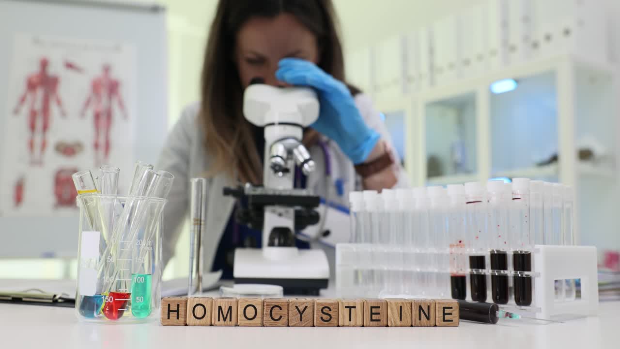Scienziato che esamina campioni di omocisteina al microscopio in laboratorio