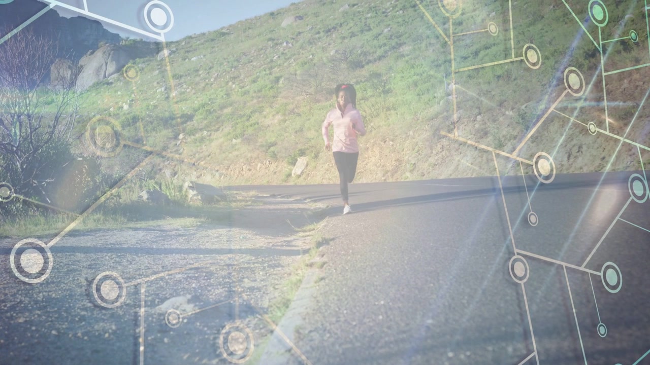 Corritrice che cammina e poi fa jogging verso la telecamera su una strada in collina, con una sovrapposizione tecnologica che traccia la corritrice