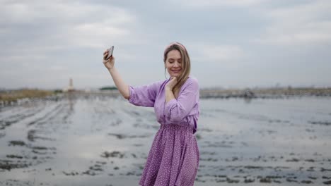woman taking a selfie in a purple dress in a rice paddy