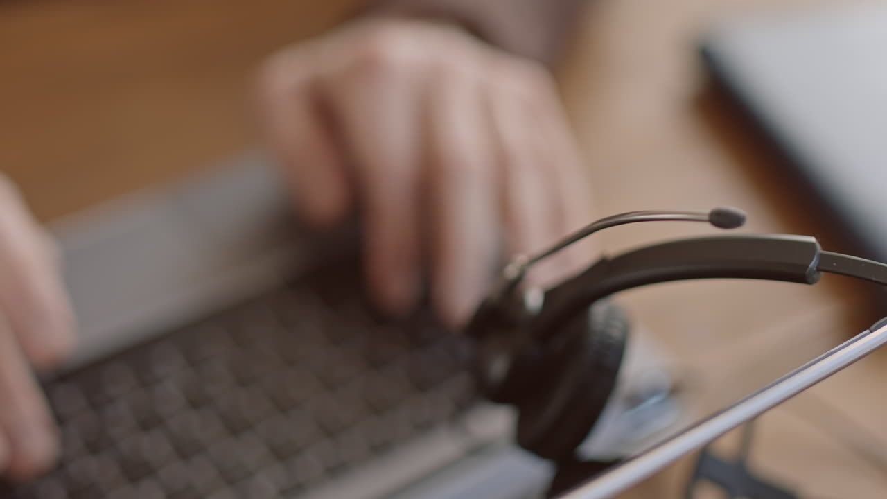 남성 사무실 직원이 노트북으로 타이핑하고 있습니다.