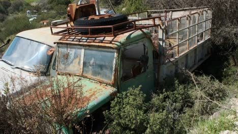 vista de un camión verde vintage en un depósito de chatarra de automóviles