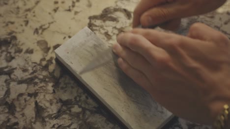 Male-Hands-Using-Knife-Sharpening-Stone---close-up