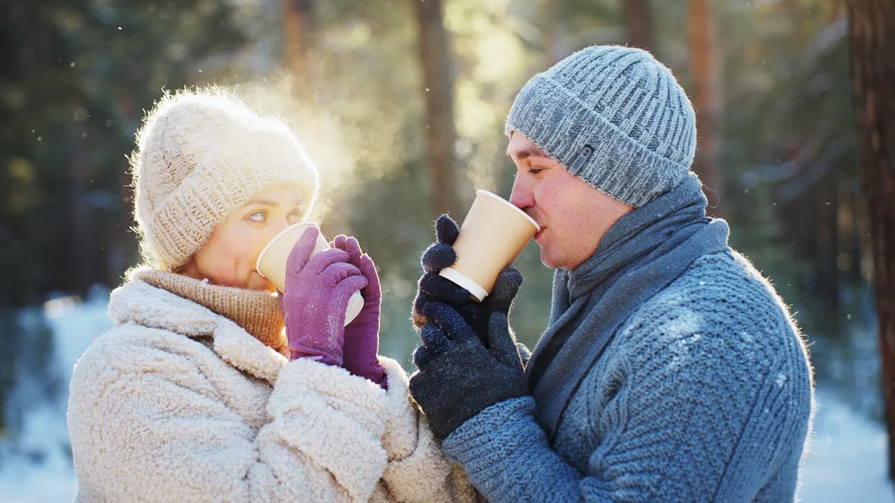 una pareja disfrutando de café en un bosque nevado