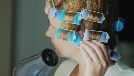 Mujer-Con-Rulos-En-La-Cabeza-Se-Seca-El-Cabello-Con-Un-Secador-De-Pelo