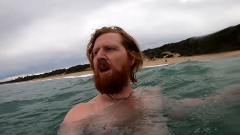 a slow motion close up shot of a man in the ocean swimming