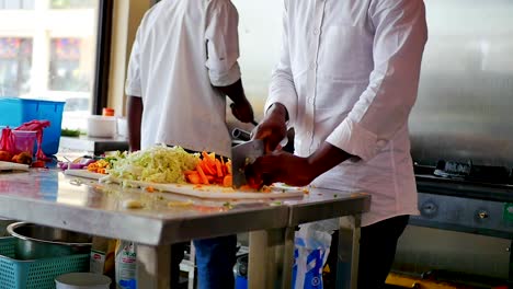 african american chef chopping vegetables on a white board