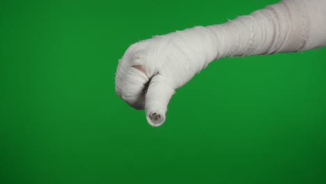 bandaged hand giving thumbs down on green screen