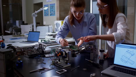 two women engineers working on an electronic project in a lab