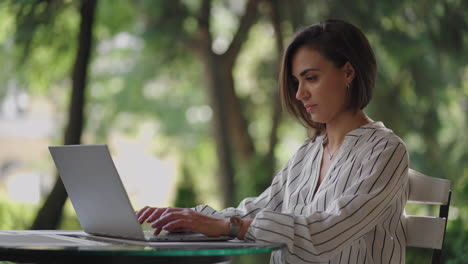 Business-Woman-Brunette-Arabic-Hispanic-Ethnicity-Works-remotely-while-sitting-in-a-summer-cafe-on-a-sunny-day.