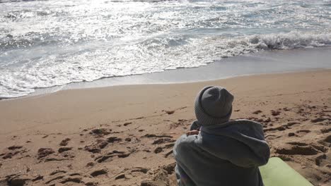 person meditating on the beach by the ocean