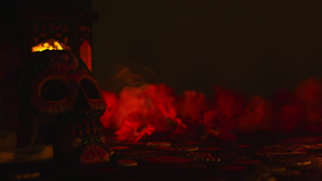 las velas se apagan junto al cráneo decorado con flores que celebran la fiesta mexicana de dia de muertos o día de los muertos contra un fondo oscuro