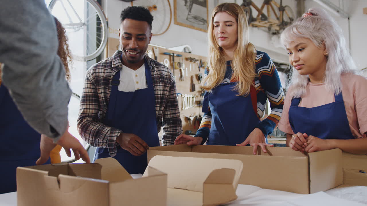 equipo multicultural en el taller desempaquetando y montando un marco de bicicleta de bambú sostenible construido a mano