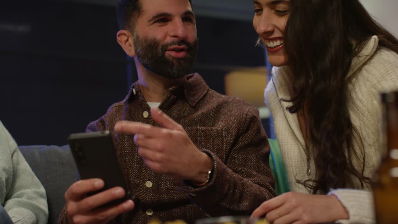 grupo de amigos disfrazándose en casa o en un bar celebrando en la fiesta del día de san patricio mirando fotos en el teléfono