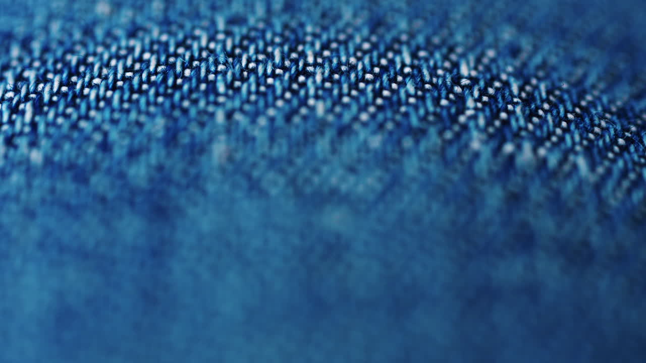 Close up of blue denim fabric texture showing fine threads and detailed textile pattern