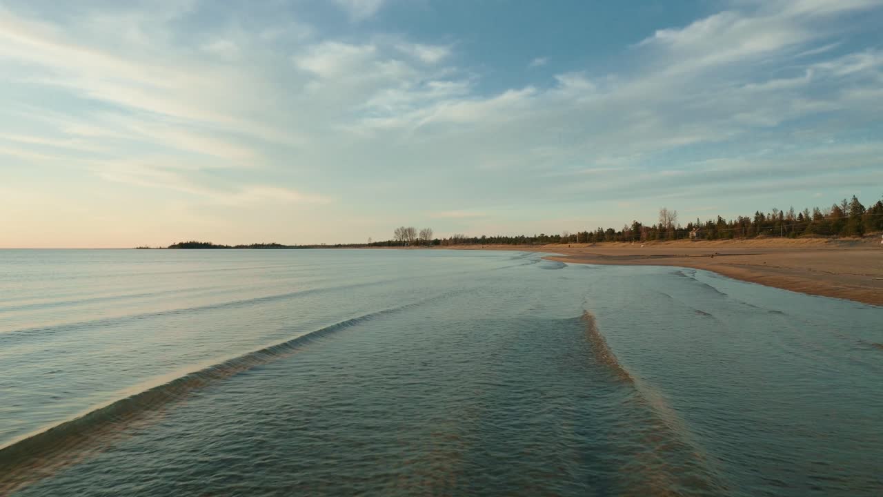 puesta de sol pacífica sobre el lago huron con olas suaves y un cielo tranquilo