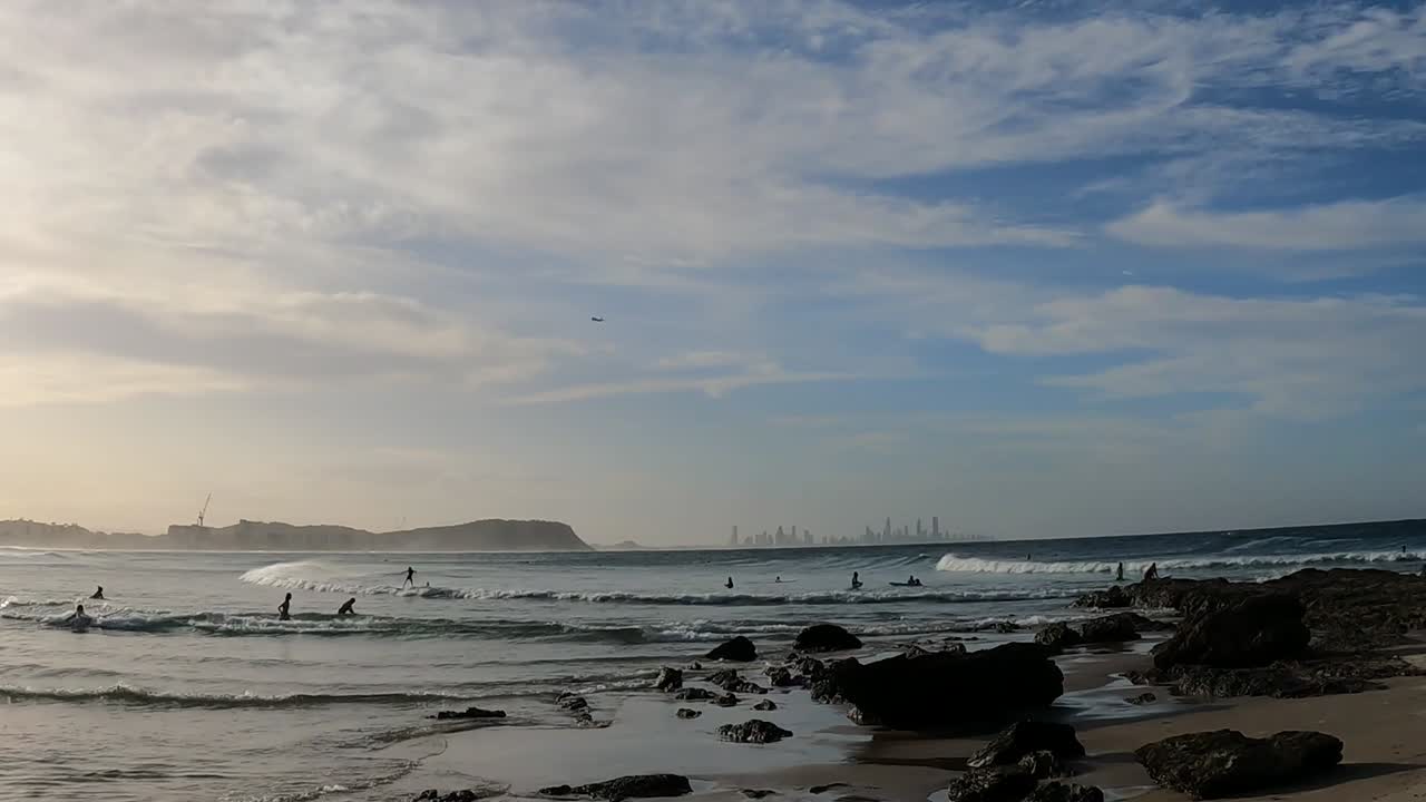 파도, 서퍼, 그리고 커럼빈 해변에서 해가 지는 모습