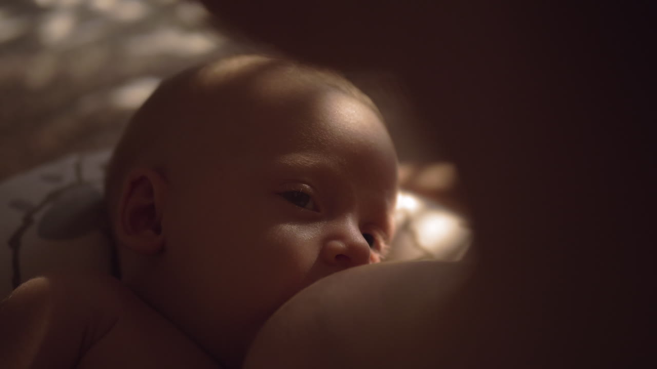 madre amamantando bebé somnoliento de tres meses