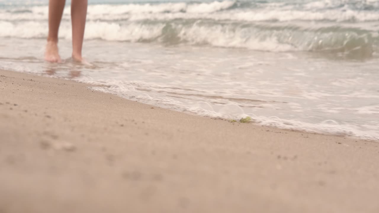 los pies de los turistas junto al mar.