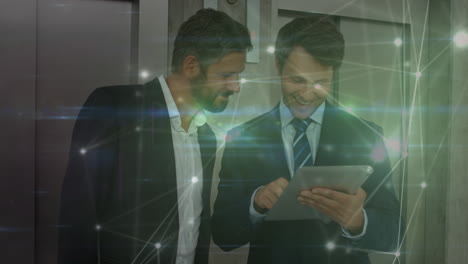 animation of network of connections over caucasian businessmen using tablet