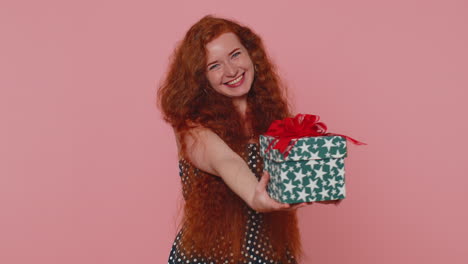 la chica pelirroja que presenta una caja de regalos de cumpleaños ofrece un regalo envuelto un bono de carrera para celebrar