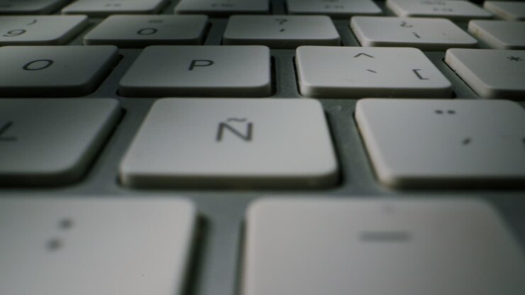 Dette er et detaljeret billede af et slankt, moderne tastatur, der fremviser dets glatte taster og elegante overordnede design.