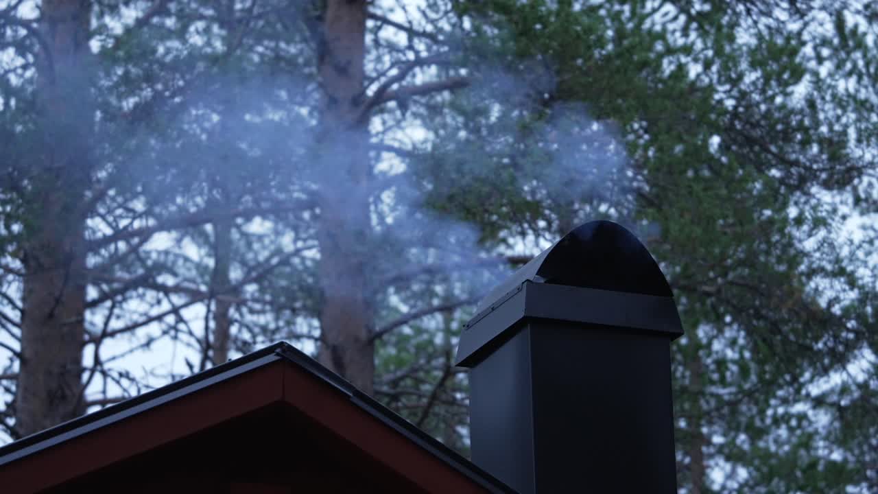 Chimney smoking at forest cabin in Muddus National Park, Sweden