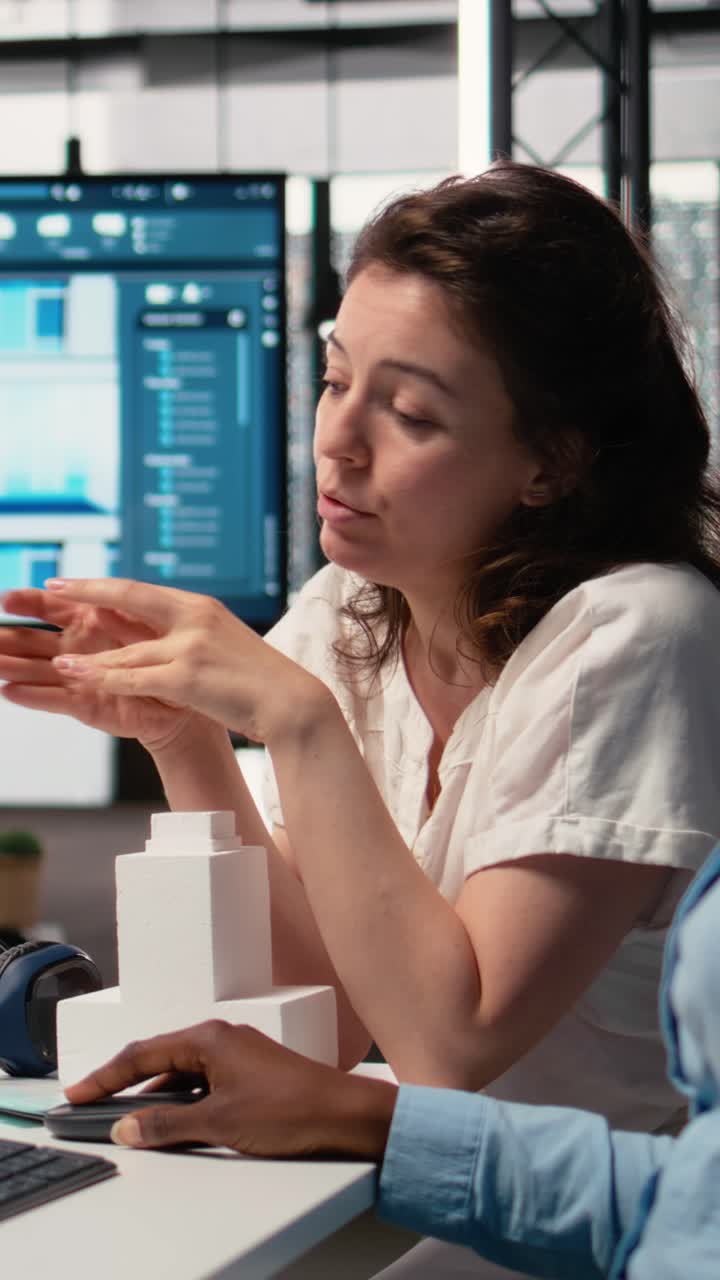 Vertical Video Multiethnic real estate team evaluate a residential project with 3D models