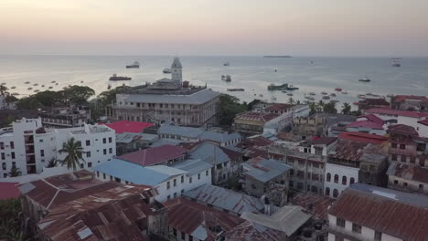 sartenes aéreas al atardecer sobre la ciudad de piedra, frente al mar de zanzíbar, barcos amarrados