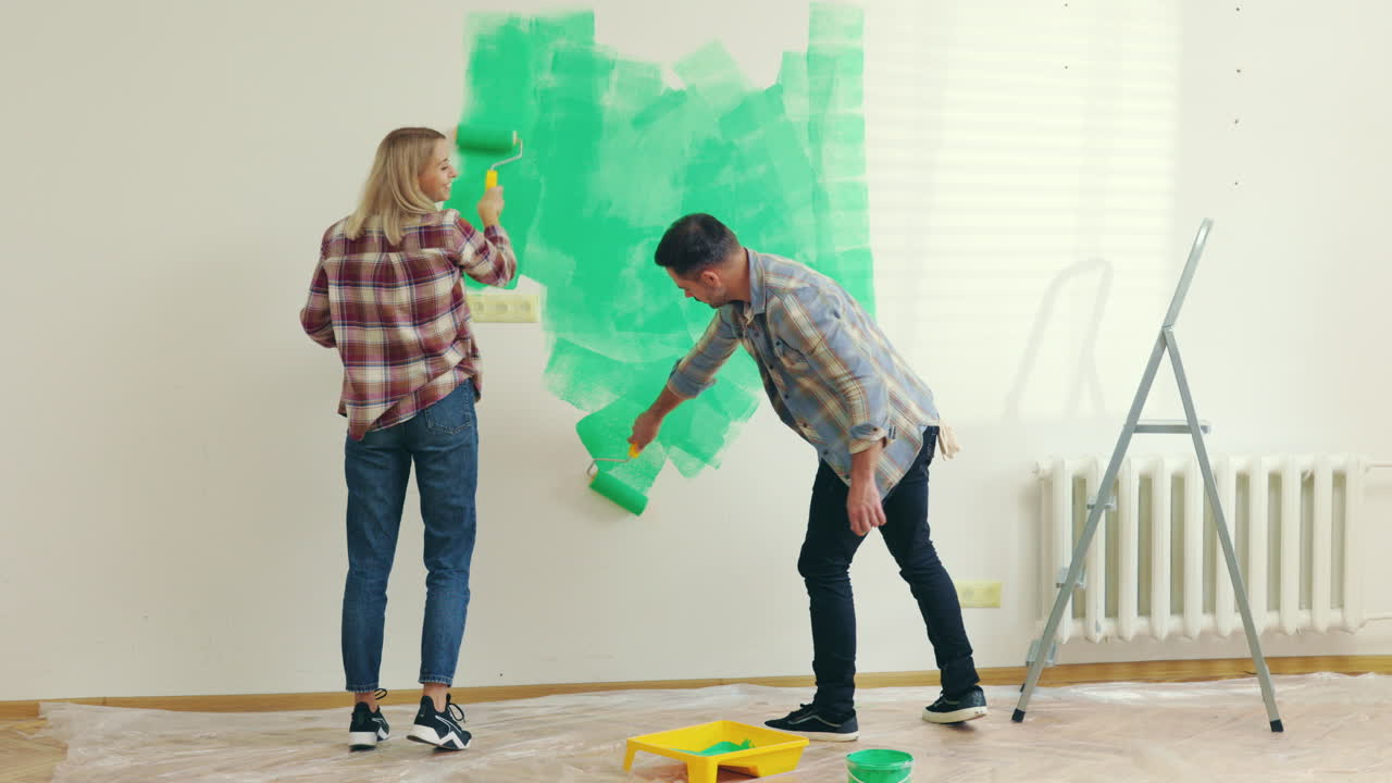 Couple Painting a Wall Green