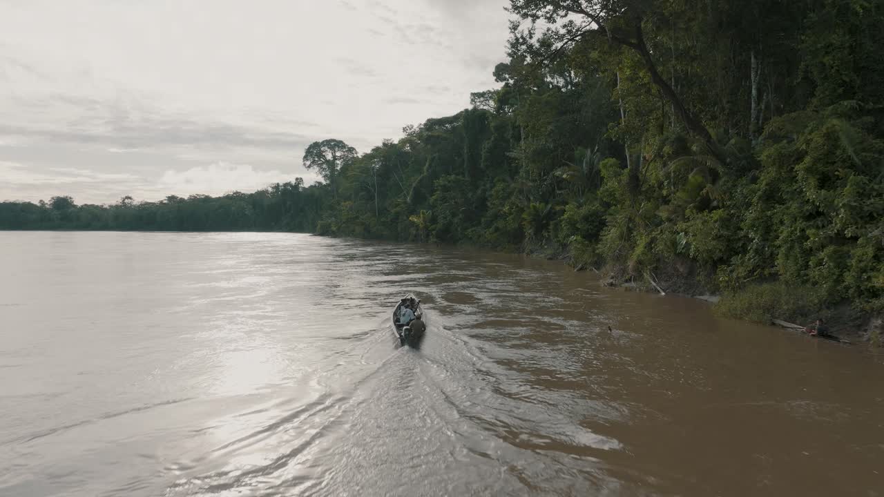 toma aérea de un pequeño barco de pasajeros navegando en el río amazonas