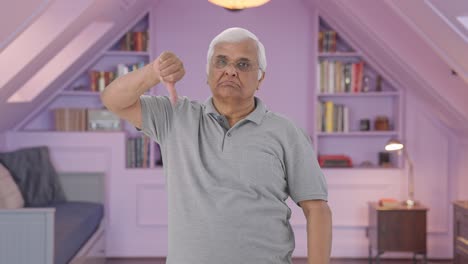 anciano indio enojado mostrando los pulgares hacia abajo