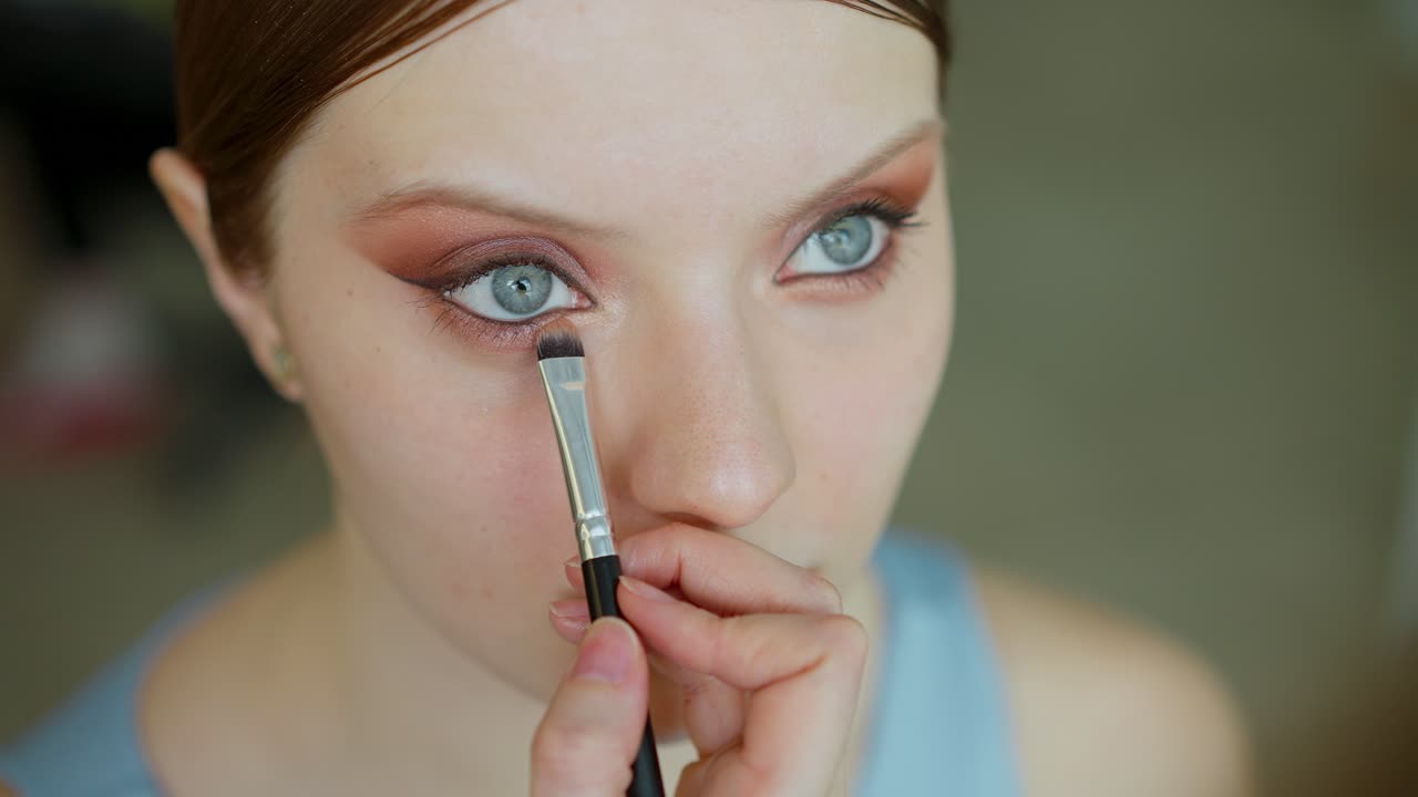 Woman getting eye makeup application