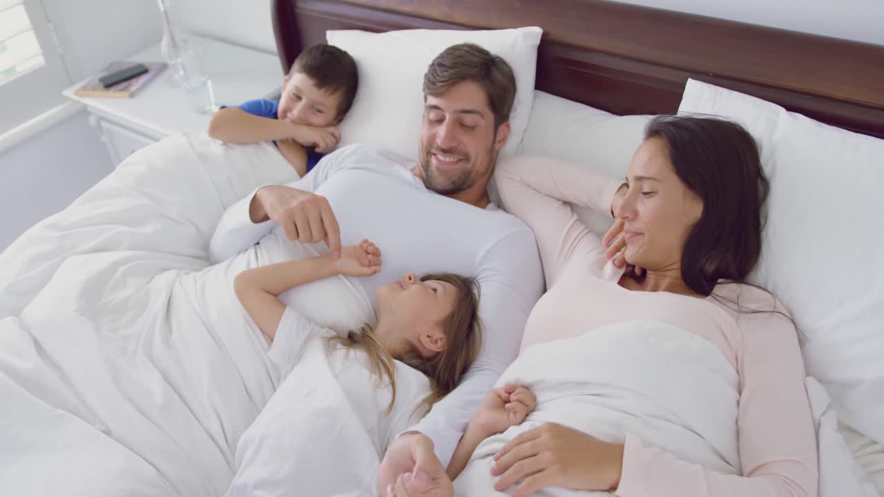 Familia relajándose juntos en la cama en el dormitorio en casa 4k ...